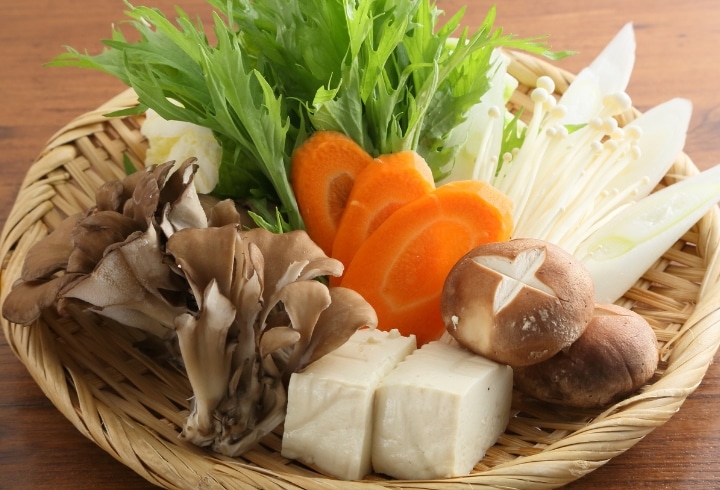 ざるに盛った鍋野菜・きのこ・豆腐
